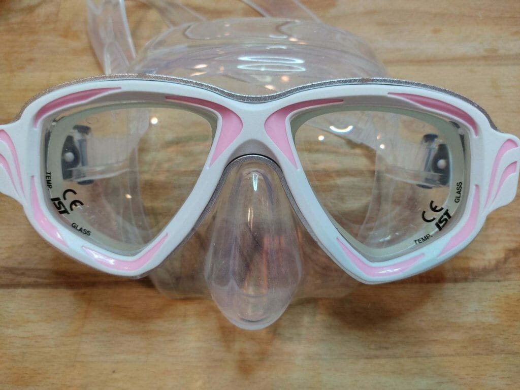 Scuba diving mask with light pink frame and higher strength prescription lenses.