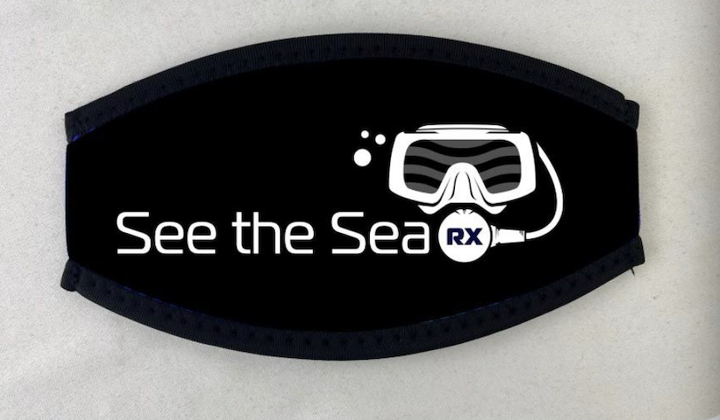Black Neoprene Strap Cover Neoprene mask strap cover with the See The Sea logo, designed for comfort and to prevent hair tangling while diving. Pictured in black.
