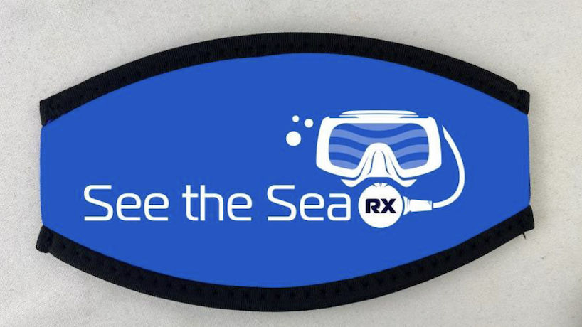 Blue Neoprene Strap Cover Neoprene mask strap cover with the See The Sea logo, designed for comfort and to prevent hair tangling while diving. Pictured in blue.